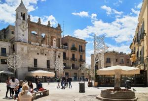 a group of people sitting in a plaza in front of a building at Luxury Borgo Antico in Bari