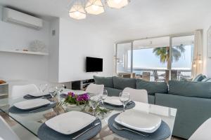 een woonkamer met een tafel en een blauwe bank bij On The Beach Sea View Patricia 132 in Marbella