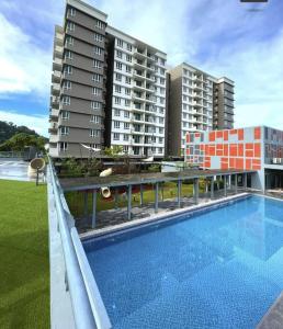 una piscina di fronte ad alcuni edifici alti di Homestay Sandakan CLL a Sandakan