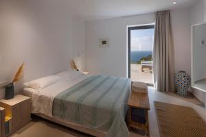 1 dormitorio con cama y vistas al océano en Kechria Bay Villas, en Skiathos