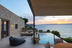 a house with a swimming pool and a view of the ocean at Kechria Bay Villas in Skiathos
