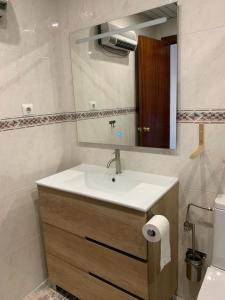 La salle de bains est pourvue d'un lavabo, d'un miroir et de toilettes. dans l'établissement MARINA CUNIT, à Cunit