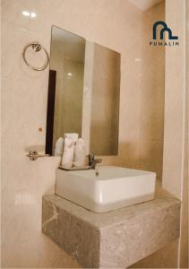 a bathroom with a white sink and a mirror at Villa Pumalin in Luang Prabang