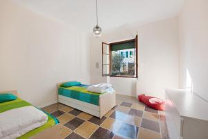 um quarto com uma cama, uma secretária e uma janela em Casa Dante - Arenzanohost em Arenzano