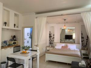 a bedroom with a bed and a table and a kitchen at Villa Magnolia in Manot in Manot