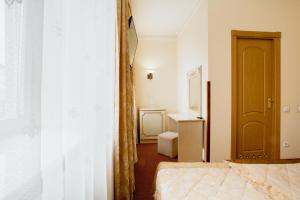 um pequeno quarto com duas camas e uma porta em Hotel Natalia 18 em Lviv
