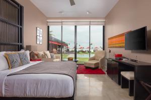 a bedroom with a bed and a desk and a television at W15 in Weligama