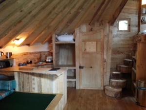 a kitchen in a log cabin with an open door at Cabane perchée - Les Cabanes de Fallot - sauna bain-froid piscine in LʼIsle-Bouzon