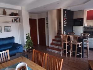 a kitchen and living room with a blue couch and chairs at Apartamento Les Fonts in Polop +18 photos