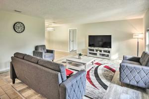 a living room with two couches and a flat screen tv at Palm Coast Home about 7 Mi to Flagler Beach! in Palm Coast
