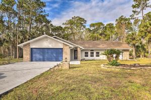 a brick house with a blue garage at Palm Coast Home about 7 Mi to Flagler Beach! in Palm Coast