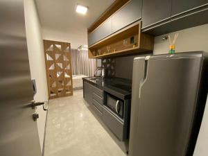 uma cozinha com um frigorífico de aço inoxidável e armários de madeira em Sky Concept 816 em Maceió