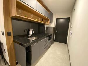 eine kleine Küche mit Spüle und Kühlschrank in der Unterkunft Sky Concept 816 in Maceió