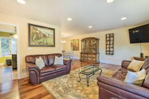 a living room with leather couches and a television at Atlanta Abode with Yard in a Tranquil Setting! in Norcross