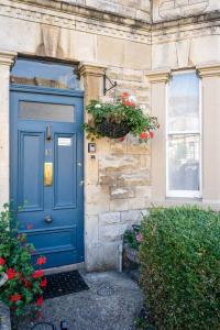 a blue door on the side of a building with flowers at Central Bath apartment in Bath