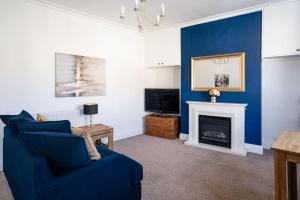 a living room with a blue couch and a fireplace at Central Bath apartment in Bath