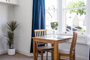 a dining room table with two chairs and a window at Central Bath apartment in Bath