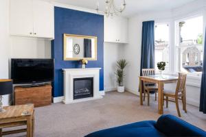 a living room with a fireplace and a blue wall at Central Bath apartment in Bath