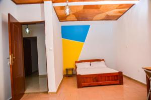 a bedroom with a bed and a colorful wall at Appartement meublé 2 chambres avec salle de bain - 1 salon - 1e cuisine - La Concorde - Quartier Nkomkana in Yaoundé