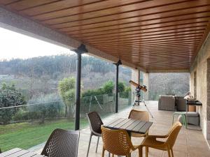 a patio with a table and chairs on a deck at Quinta Picouto de Cima in Guimarães
