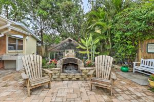 a backyard with two chairs and a stone fireplace at 4 Mi to Dtwn Home with Pool and BBQ in Bradenton in Bradenton