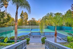 una pista de tenis con bancos y palmeras en Rolling Hills Estates Condo with Free WiFi!, en Rolling Hills Estates