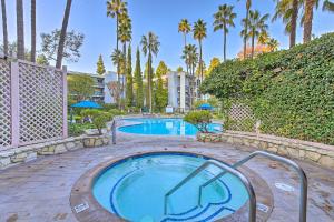 una piscina con bañera de hidromasaje y palmeras en Rolling Hills Estates Condo with Free WiFi!, en Rolling Hills Estates