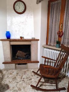 Pokój z krzesłem, zegarem i kominkiem w obiekcie Casa Fontanelle w mieście Celano