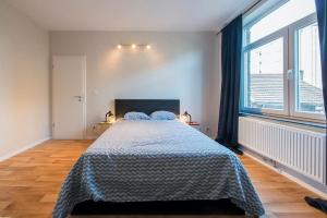 een slaapkamer met een bed en een groot raam bij Appartement 4 chambres à Liège in Luik