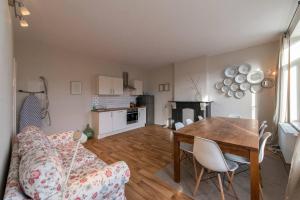 uma sala de estar com uma mesa e um sofá e uma cozinha em Appartement 4 chambres à Liège em Liège