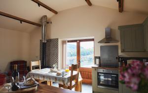 a kitchen with a table and a dining room at The Old Dairy - Boutique Countryside Cottage at Harrys Cottages in Pen y Clawdd