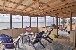 een afgeschermde veranda met stoelen, een tafel en een televisie bij Waterfront Louisiana Vacation Rental with Dock! in Alliance