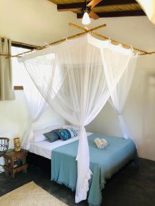 een slaapkamer met een bed met een klamboe bij Aruanã - Praia do Sargi in Serra Grande