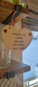 a heart shaped sign hanging on a wall at Cosy Country Retreat in the Brecon Beacons in Crickhowell