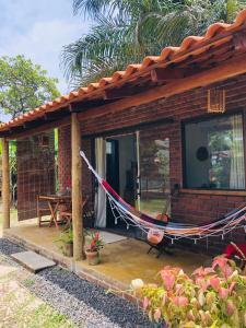 een hangmat aan een huis met een patio bij Aruanã - Praia do Sargi in Serra Grande