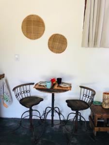 uma mesa com duas cadeiras e uma mesa com uma tigela em Aruanã - Praia do Sargi em Serra Grande