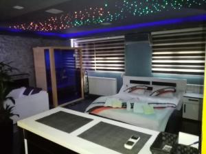 a room with a bed and a desk and a room with stars at Spa Apartment in Belgrade
