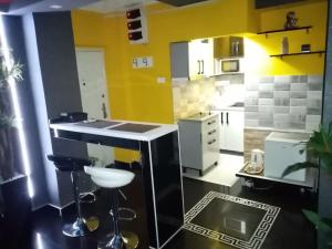 a kitchen with yellow walls and a counter with stools at Spa Apartment in Belgrade +4 photos