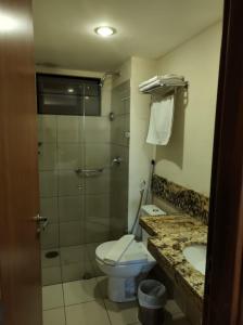 y baño con aseo, ducha y lavamanos. en Flat Suite Natal, en Natal