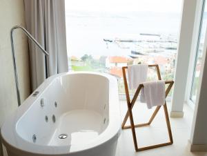 a white bath tub in a bathroom with a window at Otantus Hotel in Muros