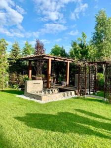 - un kiosque dans un parc avec de l'herbe verte dans l'établissement Luxury Villa - JessApart Walendia, à Walendów