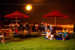 a group of people sitting under umbrellas on the beach at night at W15 Weligama in Weligama +101 photos