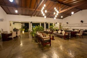 a large room with tables and chairs and a dining room at Sigiriya Wewa Addara Hotel - Hotel By The Lake in Sigiriya