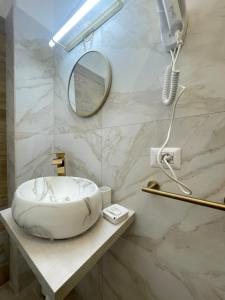 uma casa de banho com um lavatório redondo e um espelho em San Pietro Rooms 84 em Roma