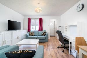Crawley 1-Bedroom Pet Friendly Apartment في Three Bridges: غرفة معيشة مع أريكة وطاولة