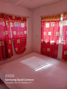 a small room with red curtains and a bed at Hotel la Quebrada in Acapulco