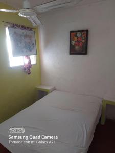 a bedroom with a white bed and a window at Hotel la Quebrada in Acapulco