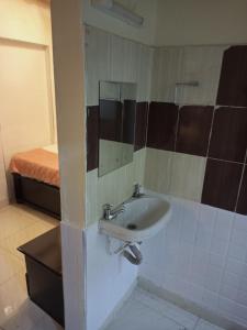 a bathroom with a sink and a bed at Beach View Hotel - Kisumu in Kisumu