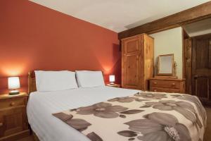 a bedroom with a bed and two lamps and a mirror at The Mountain Cottages - Millrace in Coniston