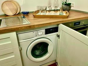 a kitchen with a washing machine under a counter at VOH Studio MITTEN in Vohenstrauß, Smart-TV, Parkplatz in Vohenstrauß